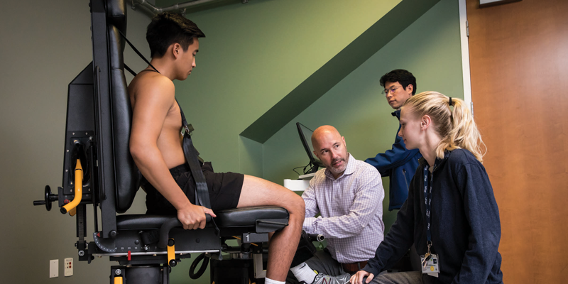 A team of PTs examine patient's knee