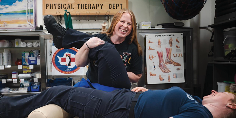 A PT in Antarctica stretches out a patient