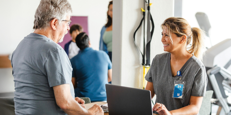 A PT and her laptop with a patient