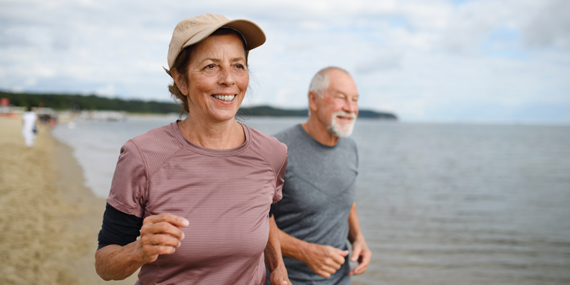 Older couple running on the beach